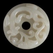 A Chinese 'chilong' jade disc, bi: the stone of pale celadon colour,