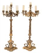 A pair of gilt metal five-light candelabra: with urn-shaped nozzles on scrolling arms,