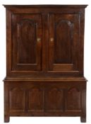 An 18th Century oak side cupboard:, in two parts, with a moulded cornice,