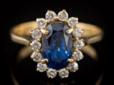 A sapphire and diamond mounted oval cluster ring: with central, oval sapphire approximately 9.