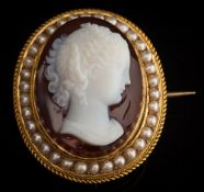 A Victorian layered agate cameo portrait brooch: the white agate cameo carved depicting a young