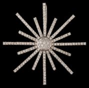 A modern diamond star burst pendant/brooch: pave-set with round brilliant-cut diamonds,
