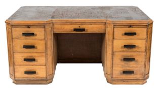 An Art Deco oak kneehole desk:, of breakfront and canted design,