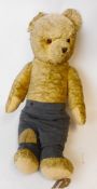 A large pale plush Teddy bear: with rounded wide-apart ears, glass eyes,