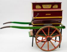 A Spanish Faventia miniature barrel organ on cart:,