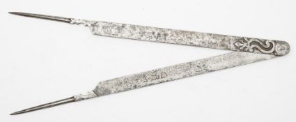 A pair of 17th century steel dividers:, of flat interlocking form with scroll decorated fulcrum,