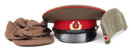 A WWII German M43 hat, together with a Russian peaked cap and a post war German forege cap:,