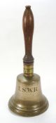 A LSWR crossing bell:, with turned wooden handle and brass ferrule, black script to body,