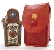 A brown bakelite Coronet Midget camera in a red case:.