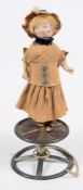An early 20th century Continental bisque doll on a spinning base:,