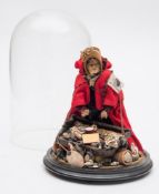 An early 20th century peddler doll under glass dome:,