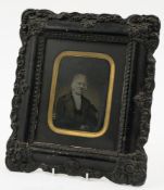 A Victorian ambrotype portrait of a seated gentleman in an ebonised moulded frame:,