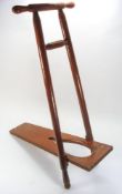 An early 20th century mahogany boot pull:, the folding base board between turned uprights,
