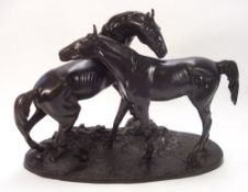 A 20th century bronze model of a mare and stallion,: unsigned on a naturalistic oval base, 52cm.