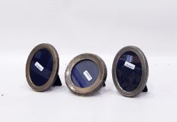 Three silver mounted photograph frames one circular,