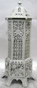 White painted iron conservatory heater with overall pierced decoration and hinged panel door,
