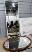 An oval bevelled oak framed mirror, 82 cms, with a wall hanging mirror,