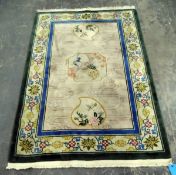 Washed Chinese style rug depicting exotic birds and with a floral border, fringed,