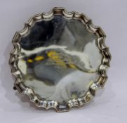 Early 20th century silver salver with piecrust rim, on three scroll feet,