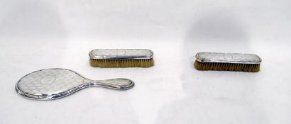 Early 20th century silver-backed dressing set comprising of mirror and two rectangular brushes,