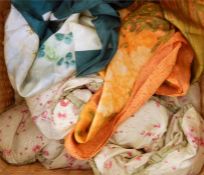 Wicker basket containing two scarves and an eiderdown
