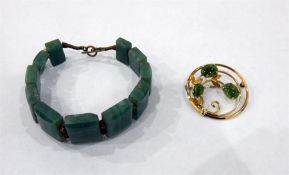 Green stone bracelet, possibly jade and a gold coloured metal brooch, circular, set with three green