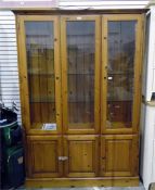 Pine wall display unit enclosed by glass panelled