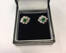 Pair emerald and diamond cluster earrings, each set centre circular facet-cut emerald having
