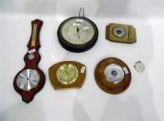 Circular aneroid barometer within an oak surround,