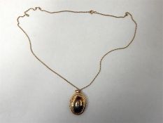 9ct gold oval locket with engraved border, set sma