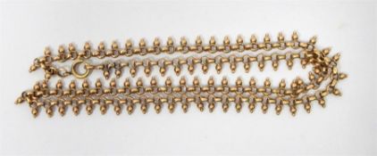 Gold necklace with circle and ball links, indistin