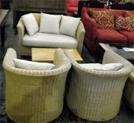 Three-piece cane conservatory/garden room suite with loose cushions and a coffee magazine table