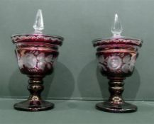 LOT WITHDRAWN Pair of Victorian cranberry glass pedestal lidded urns with clear glass finials,