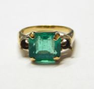 18ct gold ring set with large square cut emerald to the centre, the shoulders with settings for