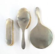 Mid 20th century silver-backed three-piece dressing table set to include mirror and two brushes,