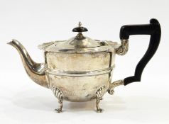 George V silver bachelor's teapot with ogee cut card borders and raised bands to the body, on tab