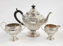 Victorian silver three-piece tea service, the top with engraved and embossed foliate decoration