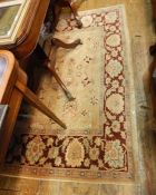 Persian style wool carpet, the cream ground with floral sprays and symbols, in pink, cream and wine,