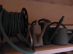 Three Plastic Watering Cans and a Hose Reel