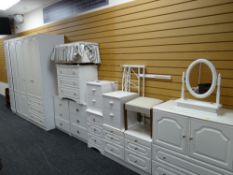 A large suite of white bedroom furniture comprising wardrobes, chest of drawers, bedside cabinets