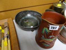 A beaten copper three-footed bowl by Dryad Lester together with a bird relief gilt & painted jug