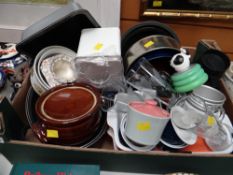 Box of various kitchen items including lidded casserole, cake tins etc