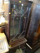 A mahogany narrow astragal glazed cabinet on a raised three-drawer base with ball & claw feet