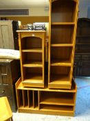 Two narrow lightwood shelving units together with a lightwood hi-fi stand