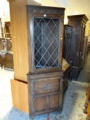 A dark oak lead glazed upper with a cupboard base corner cabinet