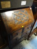 A vintage compact drop down oak bureau, one long above four short drawers on raised feet