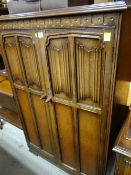 An oak Old Charm-style gentleman's wardrobe together with a matching mirrored dressing table