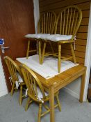 A modern honey pine kitchen / dining table together with four pine arch topped & spindle back dining