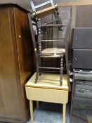 A small Formica drop leaf kitchen table, two rush topped kitchen chairs together with a small rush