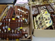 A large collection of collector's spoons on wall hanging display shelves